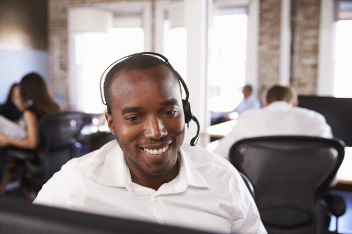 View Of Man Working In Busy Customer Service Department