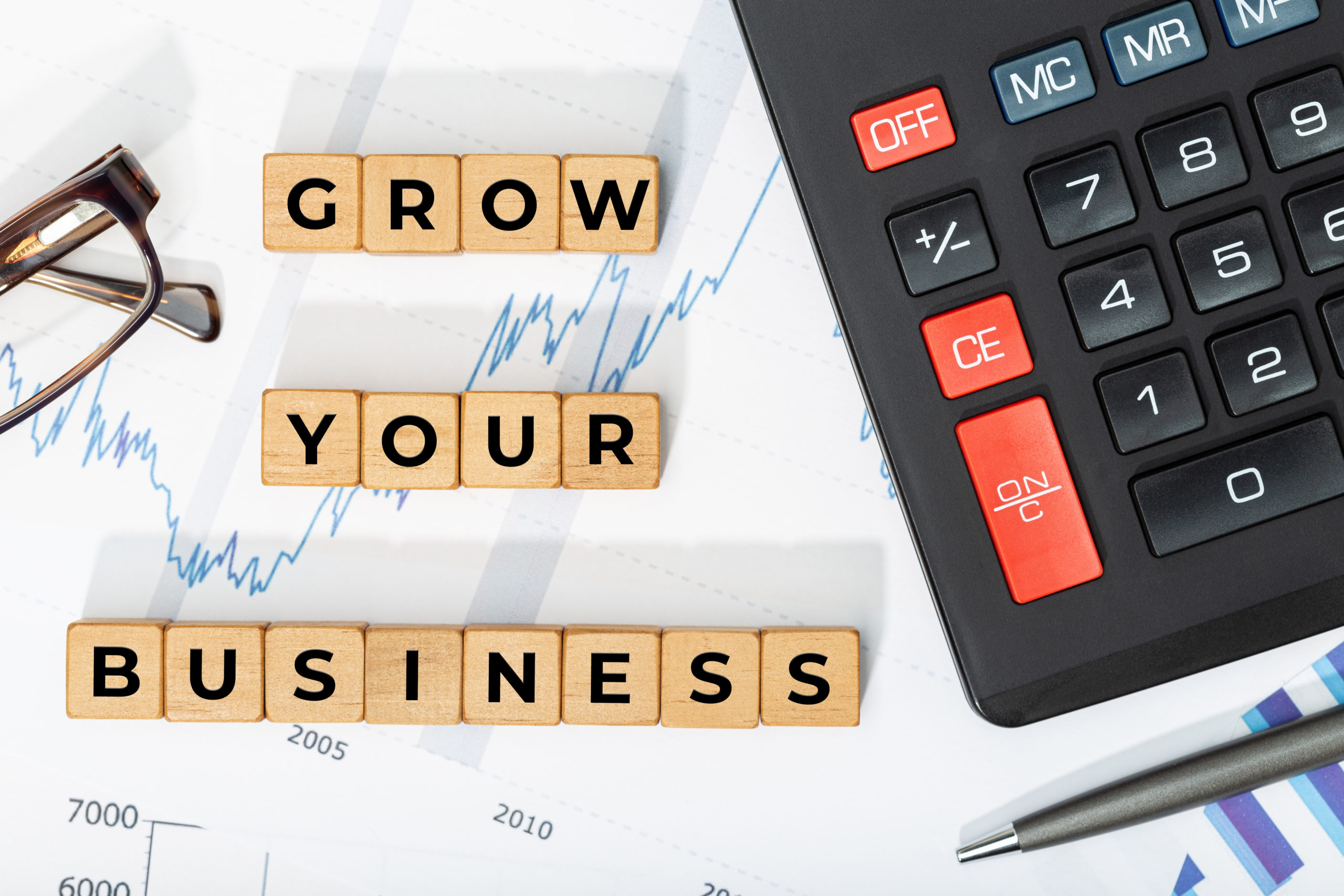 Grow your business concept. Wooden blocks with phrase, calculator and printed chars